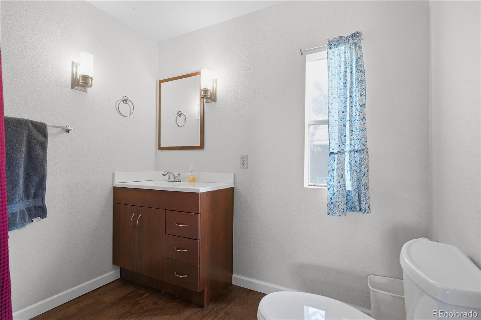 12205 Perry Street Broomfield, CO 80020 - Photo 17 of 22 a bathroom with a toilet sink and mirror