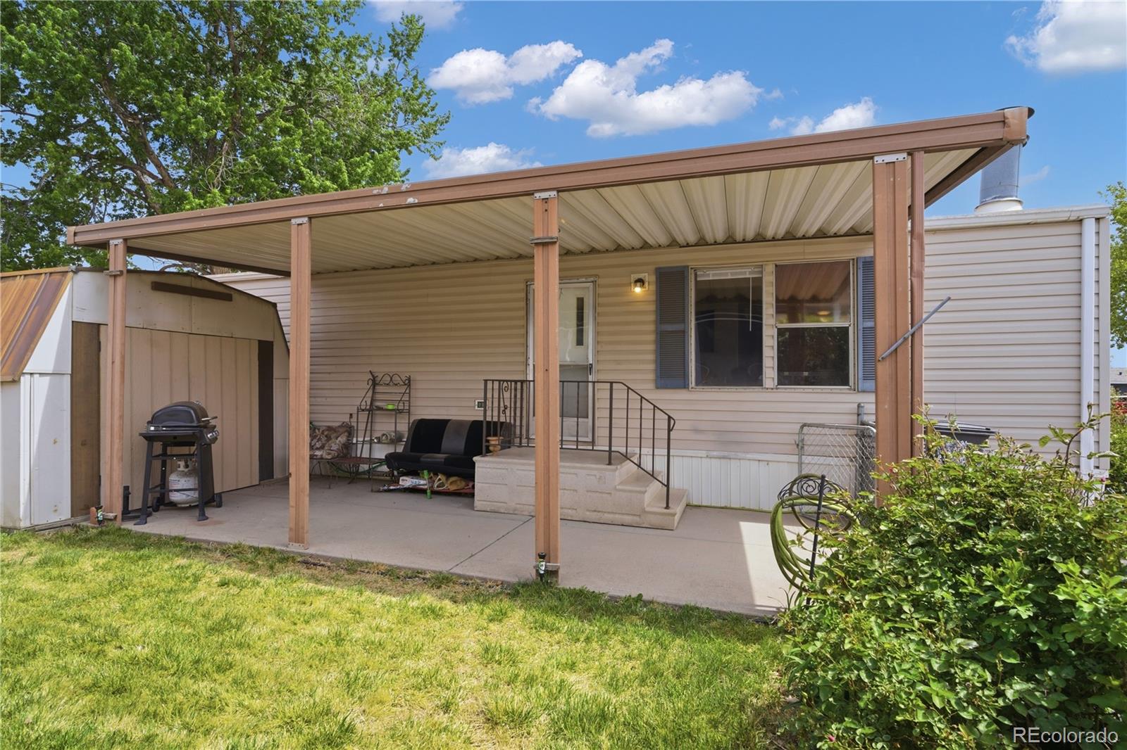 12205 Perry Street Broomfield, CO 80020 - Photo 22 of 22 a view of a house with a patio and a yard