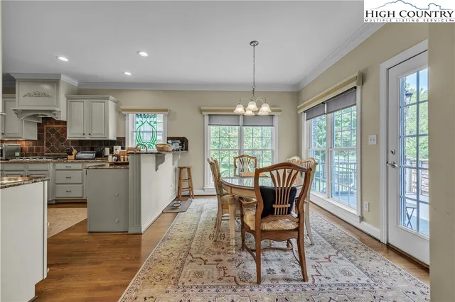a dining room with furniture a chandelier and wooden floor