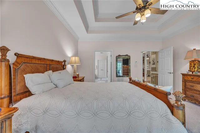 a bedroom with a large bed and a chandelier