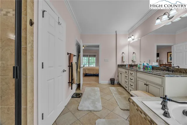 a spacious en suite bathroom with a double vanity sink a mirror and a shower