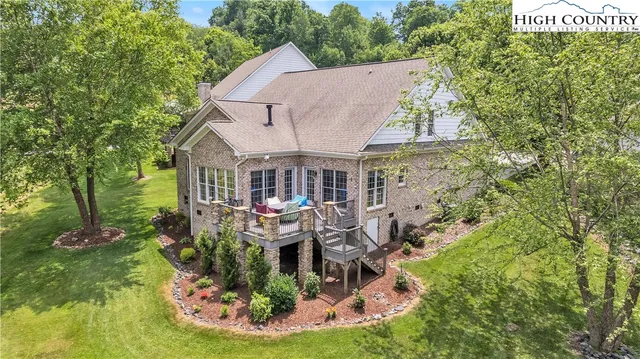 an aerial view of a house with swimming pool and mountains