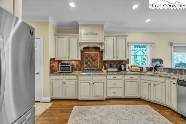 a kitchen with stainless steel appliances granite countertop a stove a sink and a refrigerator