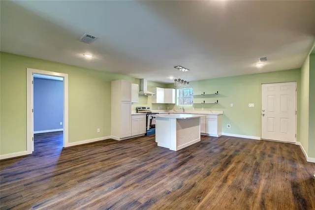 a large kitchen with cabinets and wooden floor