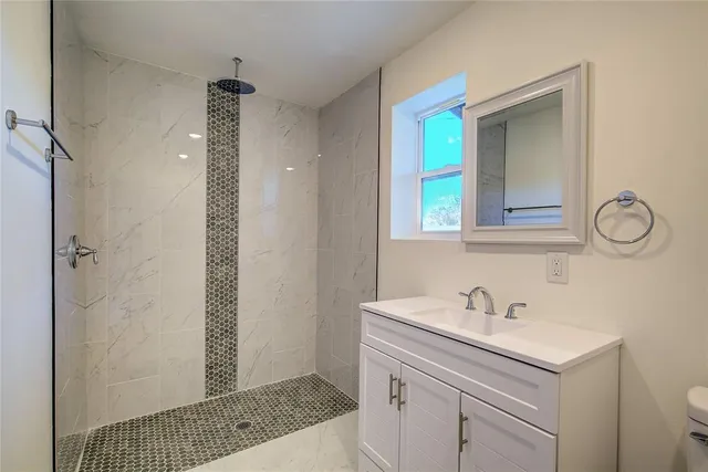 a bathroom with a sink a toilet and shower