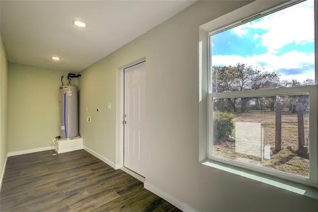 a view of hallway with wooden floor and a window