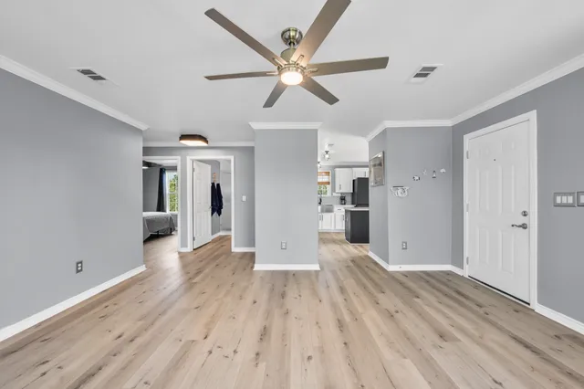 a view of a big room with wooden floor and a ceiling fan
