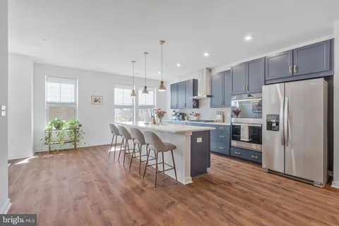 a kitchen with wooden floors and refrigerator