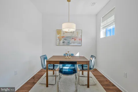 a kitchen with stainless steel appliances a dining table chairs microwave and stove top oven