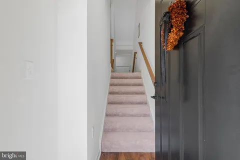 a view of staircase with white walls and a window
