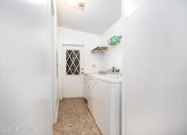 a utility room with cabinets washer and dryer