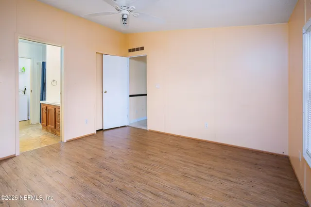 a view of an empty room with wooden floor