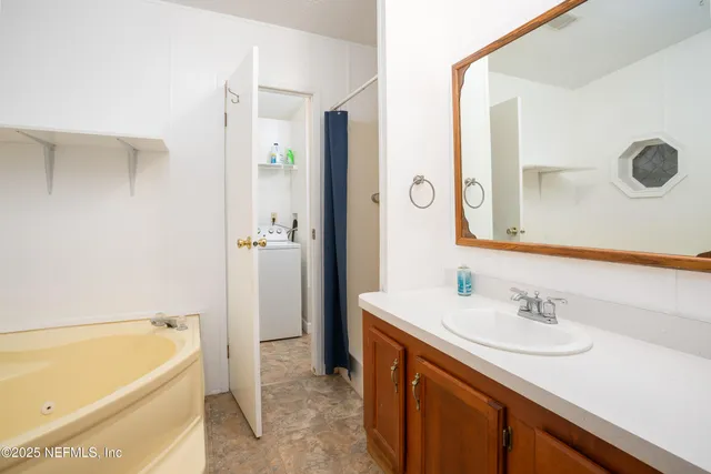 a bathroom with a tub sink and mirror