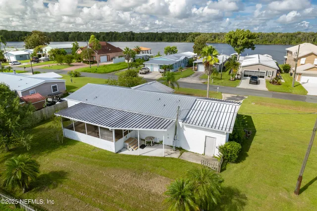 an aerial view of a house with a garden and lake view