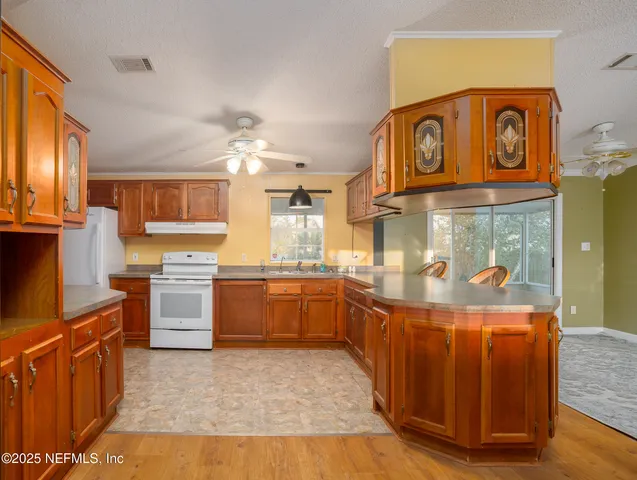 a room with kitchen island granite countertop lots of counter top space and stainless steel appliances