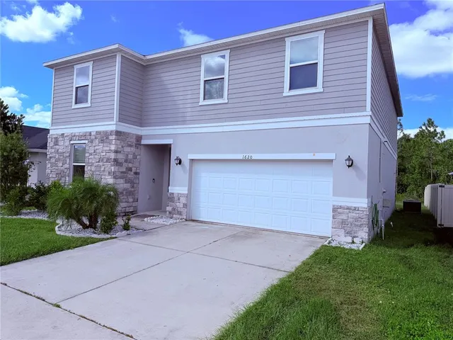 a front view of a house with a garden and plants