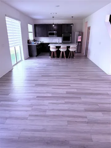 a view of a livingroom with wooden floor and furniture