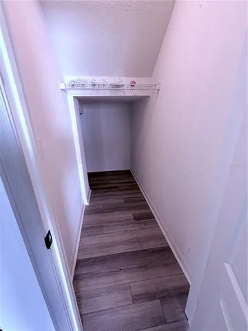 a view of a small space with wooden floor and closet