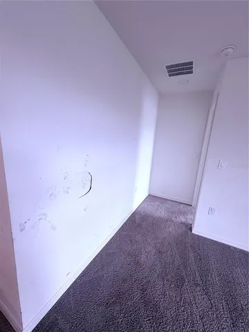 en empty room with windows and chandelier fan