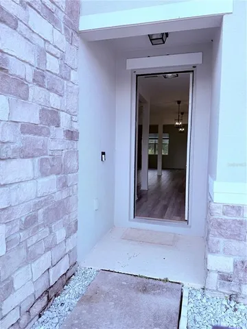 a view of a hallway with wooden floor and a living room