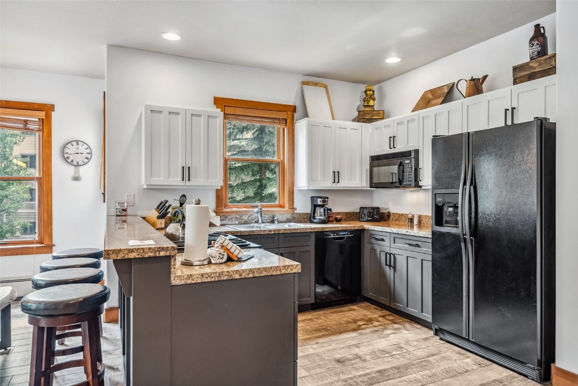 231 Hawk Circle, Unit 2324 Keystone, CO 80435 - Photo 12 of 48 a kitchen with stainless steel appliances granite countertop a refrigerator a sink dishwasher a stove and a dining table with wooden cabinet