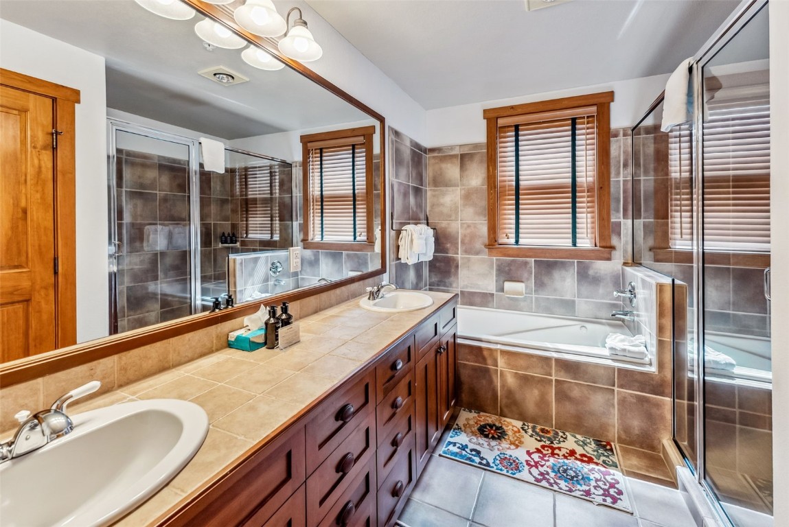 231 Hawk Circle, Unit 2324 Keystone, CO 80435 - Photo 26 of 48 a bathroom with a granite countertop tub a double vanity sink a mirror and a shower