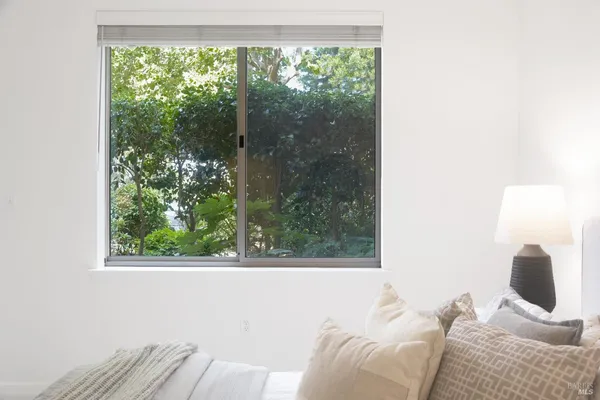 a bedroom with a bed and large window
