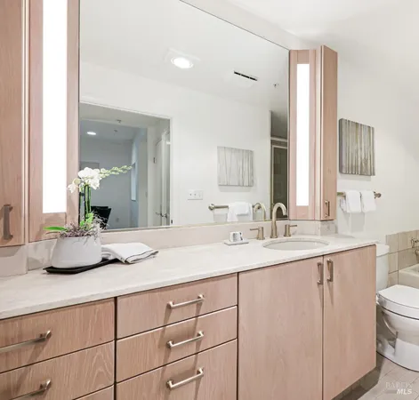 a bathroom with a granite countertop sink mirror and window