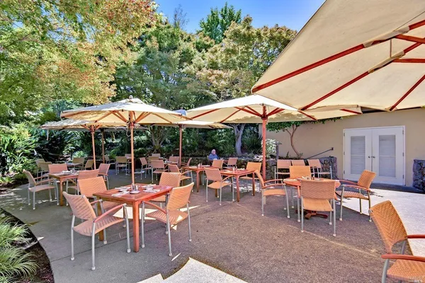 a view of patio with chairs and table under an umbrella