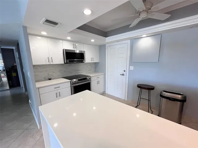 a kitchen with white cabinets and stainless steel appliances