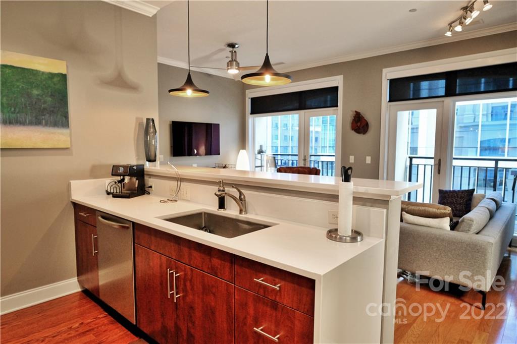 230 South Tryon Street, Unit 1109 Charlotte, NC 28202 - Photo 2 of 17 a kitchen with a sink a counter top space and living room area