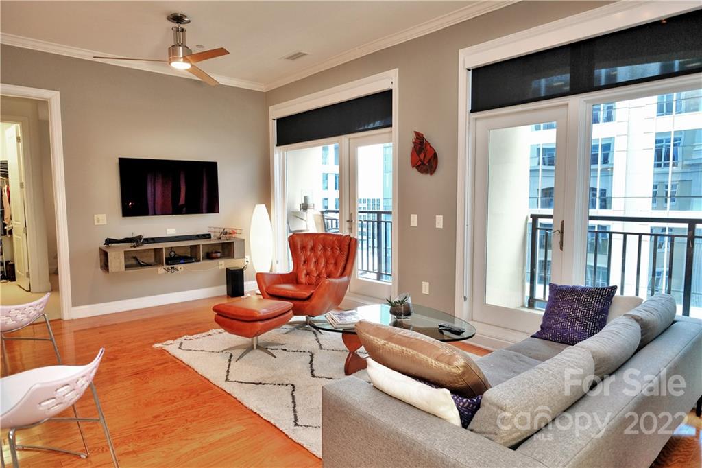 230 South Tryon Street, Unit 1109 Charlotte, NC 28202 - Photo 4 of 17 a living room with furniture a flat screen tv and a large window