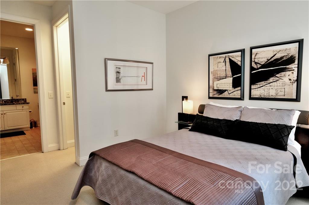 230 South Tryon Street, Unit 1109 Charlotte, NC 28202 - Photo 8 of 17 a bedroom with a bed and painting on the wall