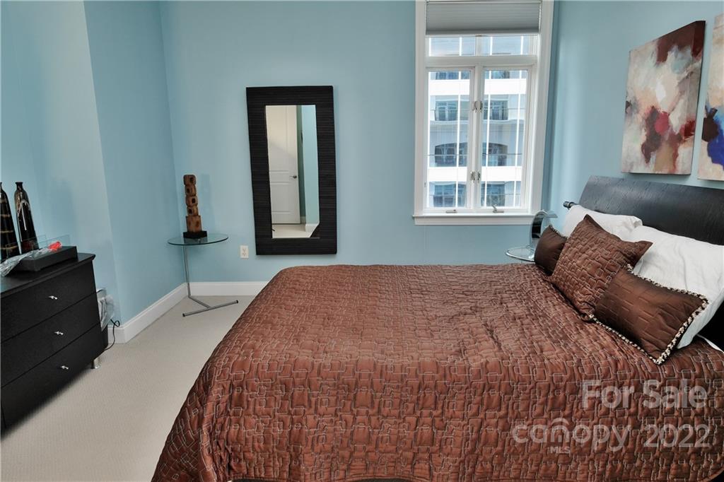 230 South Tryon Street, Unit 1109 Charlotte, NC 28202 - Photo 9 of 17 a bedroom with a bed and a painting on the wall