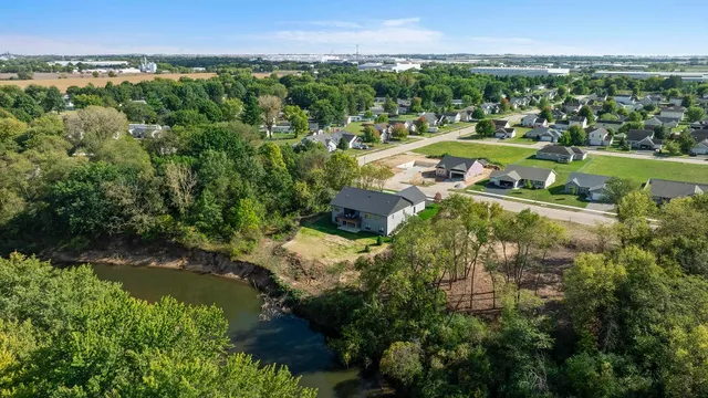 a kitchen with stainless steel appliances granite countertop a stove a refrigerator a sink a dining table and chairs with wooden floor