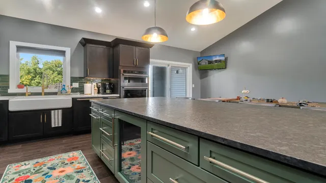 a bathroom with a granite countertop sink a toilet and a window