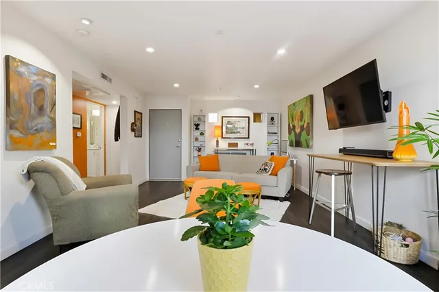 a living room with furniture a wooden floor and next to a window