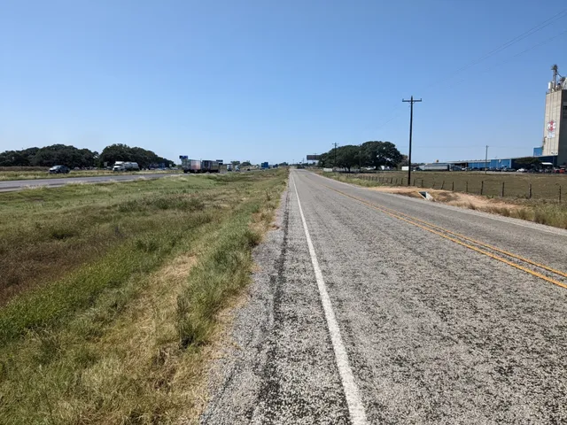 a view of a dry yard with wooden fence