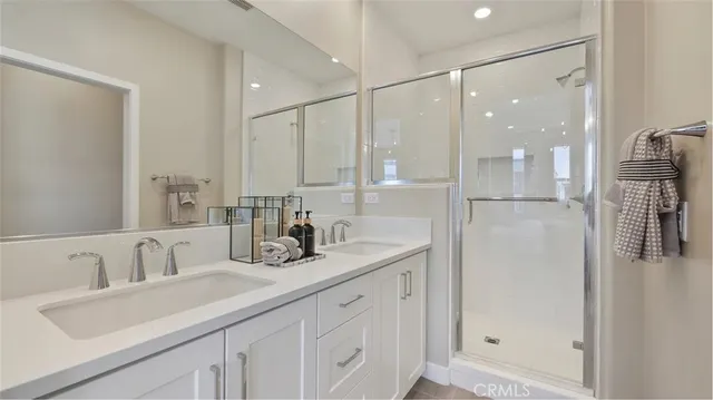 a bathroom with a double vanity sink a mirror and shower
