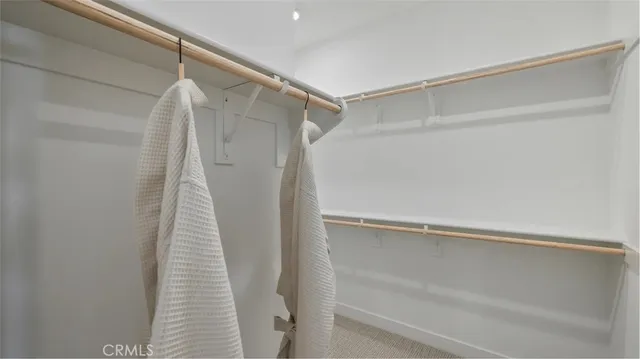 a view of walk in closet with clothes