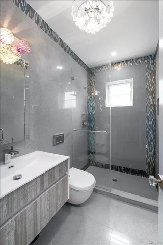 a bathroom with a double vanity sink toilet and shower