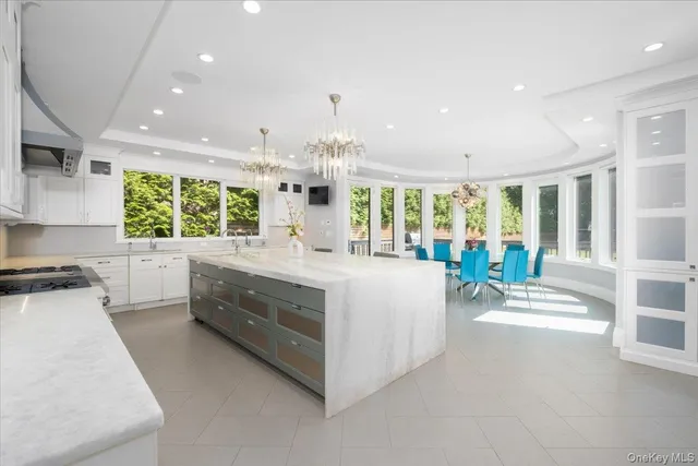 a large white kitchen with a large window and stainless steel appliances