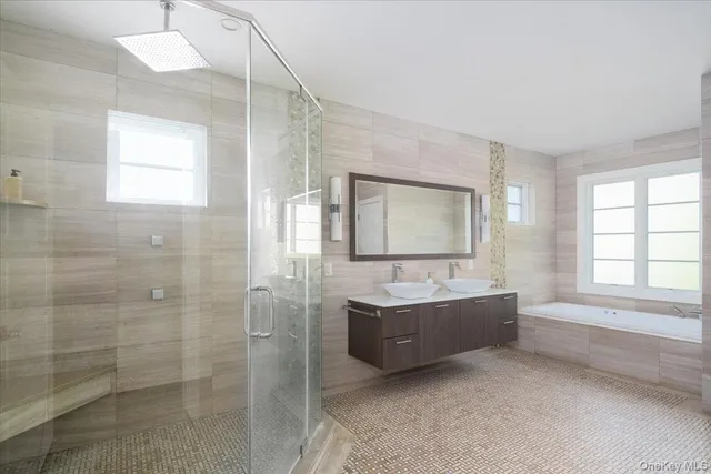 a spacious bathroom with a tub sink and mirror