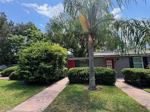 a view of a house with a yard and potted plants