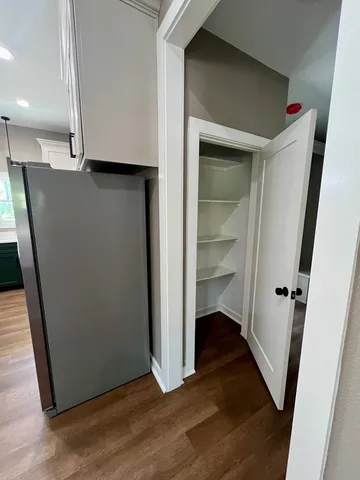 an empty room with wooden floor and entrance