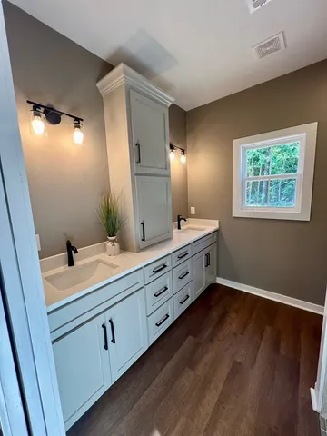 a spacious bathroom with double vanity and a mirror