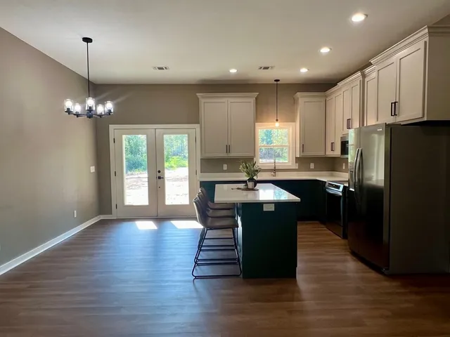 a kitchen with kitchen island granite countertop a sink cabinets and stainless steel appliances