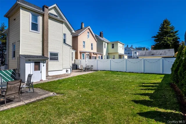 a view of a house with a yard and sitting area