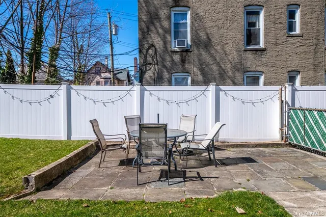 a view of a patio with table and chairs with wooden fence