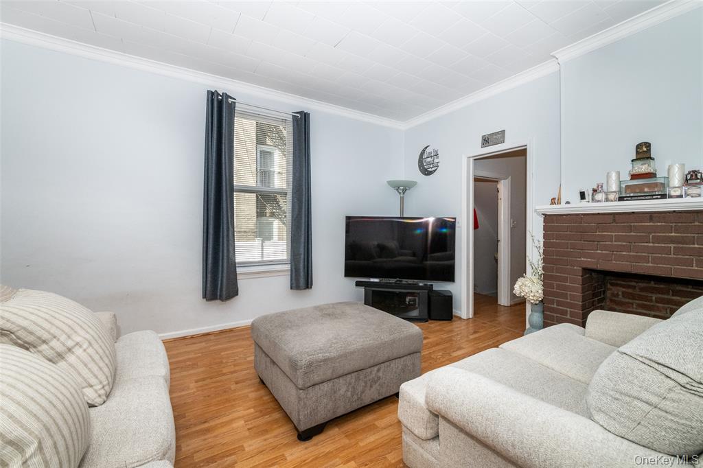 92 Washington Avenue, Unit 1 New Rochelle, NY 10801 - Photo 3 of 22 a living room with furniture a fireplace and a flat screen tv